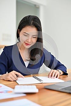 Beautiful asian female secretary or financial worker working at her office desk