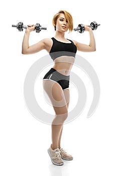 Portrait of beautiful charming sporty young woman with dumbbells on white