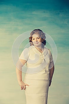 Portrait of a beautiful cheerful plump young woman in a white dress with red hair and freckles on her face is smiling