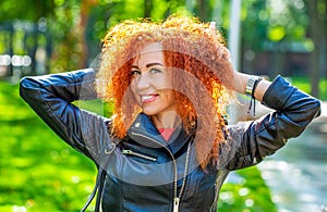 Portrait of beautiful cheerful redhead girl flying curly hair smiling laughing. Smiling happy woman curly red hair