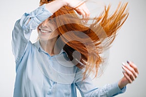 Portrait of beautiful cheerful redhead girl with flying hair smiling laughing