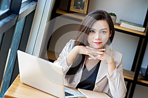 Portrait of beautiful and confident Asian business woman in working age using computer laptop technology for manage job work photo