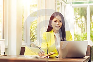 Portrait of beautiful and confident Asian business woman in working with notebook laptop and book manage job work at workplace.