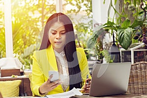 Portrait of beautiful and confident Asian business woman in working with notebook laptop and phone manage job work at workplace.