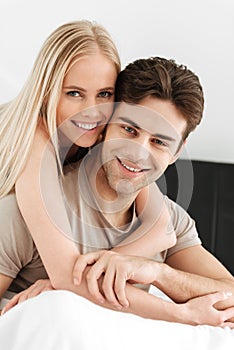 Portrait of beautiful couple looking camera in bed