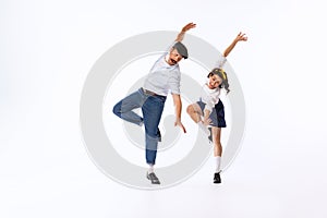 Portrait of beautiful couple, man and woman, dancing isolated over white studio background. Retro party