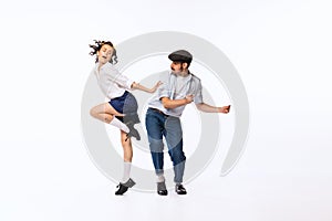 Portrait of beautiful couple, man and woman, dancing retro dance isolated over white studio background