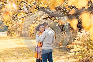 Portrait of beautiful couple man woman in love. Boyfriend and girlfriend hugging, smiling outdoor in park on a bright sunny autumn