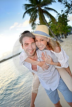 Portrait of beautiful couple at sunset on the beach with palmtrees