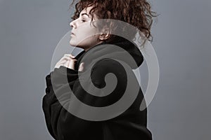 Portrait of a beautiful curly girl on a gray background