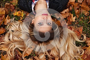 Portrait of beautiful cute blonde young woman. Posing on golden autumn nature background. Fashion photo