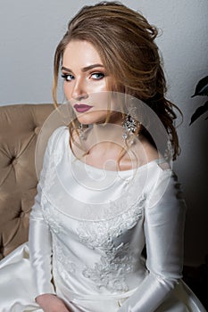 Portrait of a beautiful cute girl happy bride in an elegant dress with bright makeup in a white dress with a gorgeous wedding
