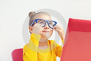 Portrait of beautiful cute little girl with glasses using laptop computer on white background