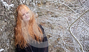 Portrait of a beautiful cute sexy seductive mature smiling redhead woman with long red curly hair, happy outside in the cold