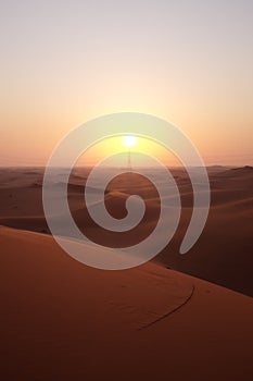 Portrait of beautiful desert sunrise with power transmission tower in the Arabian Desert, Riyadh, Saudi Arabia.