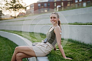 Portrait of beautiful diabetic woman with insulin pump and continuous glucose monitor on arm outdoors.