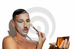 Beautiful drag queen applying makeup with white background