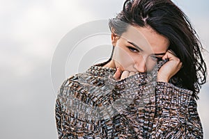 Portrait of beautiful dreamy brunette female posing against lake with blowing hair. People, lifestyle and travel concept. Sensual