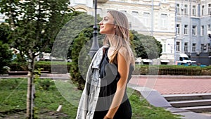 Portrait of beautiful elegant woman in dress walking in park