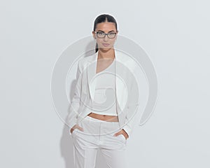 portrait of beautiful elegant woman with glasses holding hands in pockets