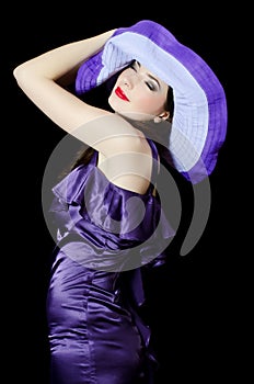 Portrait of the beautiful elegant woman in a lilac hat