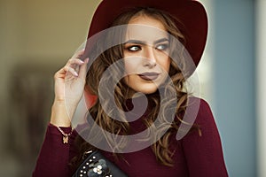 Portrait of beautiful elegant woman is wearing fashion autumn red clothes and hat infront of shop-window