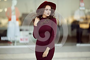 Portrait of beautiful elegant woman is wearing fashion autumn red clothes infront of shop-window