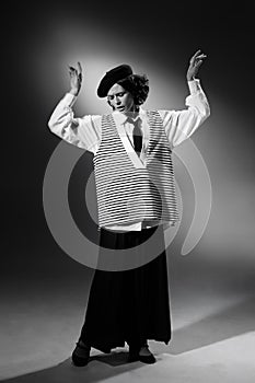 Portrait of beautiful emotive woman in stylish classical clothes, jacket and hat tenderly posing. Black and white
