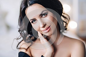 Portrait of beautiful european woman in white apartment, pretty young woman with black hair in light apartment