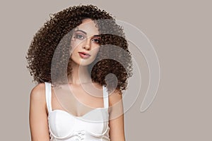 Portrait of a beautiful fashion woman. Curly hair. Lush volume. Gray background