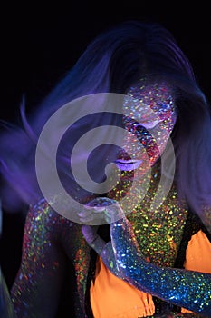 Portrait of Beautiful Fashion Woman in Neon UF Light. Model Girl with Fluorescent Creative Psychedelic MakeUp, Art