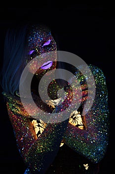 Portrait of Beautiful Fashion Woman in Neon UF Light. Model Girl with Fluorescent Creative Psychedelic MakeUp, Art