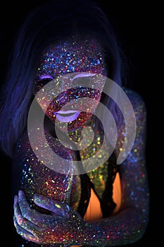 Portrait of Beautiful Fashion Woman in Neon UF Light. Model Girl with Fluorescent Creative Psychedelic MakeUp, Art