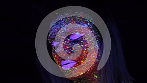 Portrait of beautiful fashion woman in neon UV light. Model girl with fluorescent creative psychedelic makeup, art