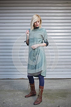 Portrait of beautiful fashionable long blonde hair girl wearing elegant dress in front of street background