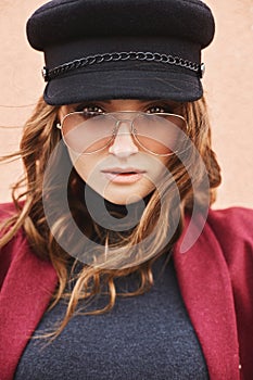 Portrait of beautiful and fashionable model woman in cap and sunglasses