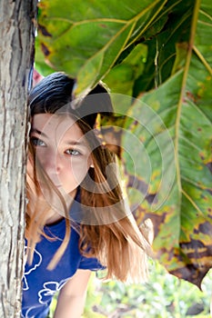 Portrait of a beautiful fashionable teenage girl among the bushes