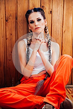 Portrait of beautiful fashionable woman with braids in jumpsuit
