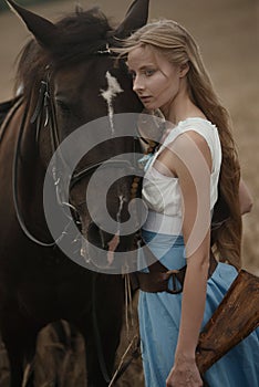 Portrait of a beautiful female cowgirl with shotgun from wild west riding a horse in the outback.