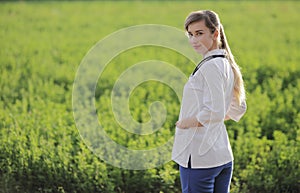 Portrait of a beautiful female doctor or nurse on green grass background