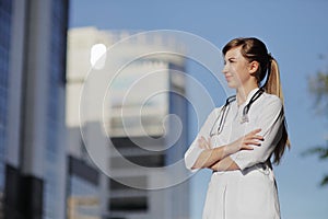 Portrait of a beautiful female doctor or nurse. Skyscraper, sky. Health concept