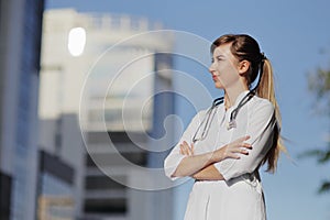 Portrait of a beautiful female doctor or nurse. Skyscraper, sky. Health concept