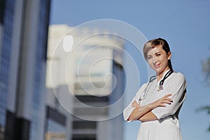 Portrait of a beautiful female doctor or nurse. Skyscraper, sky. Health concept