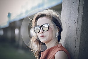 Portrait of beautiful female doctor wearing eye glasses standing and holding tablet computer in front of white background