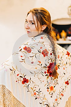 portrait of a beautiful female flamenco dancer with a embroidered floral shawl on her back