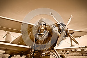 Portrait of beautiful female pilot with plane behind.