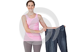 Portrait of a beautiful fit woman holding an old jeans