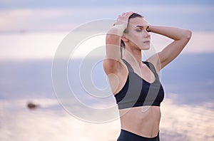 portrait of a beautiful fitness model on a background of the sea at sunset