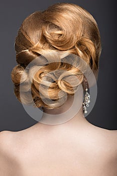 Portrait of a beautiful ginger woman in the image of the bride. Hairstyle back view