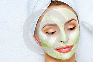 Portrait of beautiful girl applying facial mask